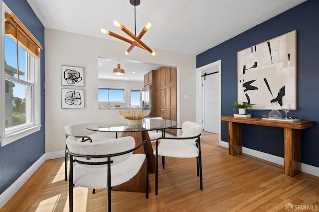 4551 Fairbairn Ave, Oakland, CA 94619 - dining space featuring a chandelier, light wood-style flooring, and a barn door