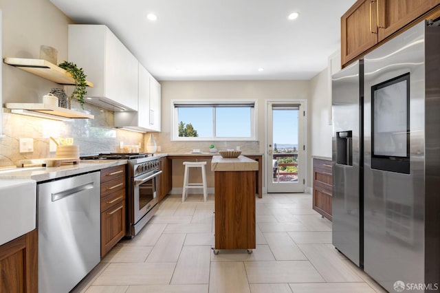 4551 Fairbairn Ave, Oakland, CA 94619 - kitchen featuring stainless steel appliances, open shelves, light countertops, a kitchen island, and tasteful backsplash