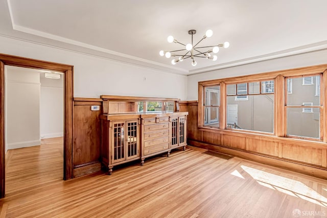 interior space featuring a wainscoted wall, an inviting chandelier, and wood finished floors