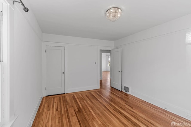 unfurnished bedroom with light wood-style floors, visible vents, and baseboards