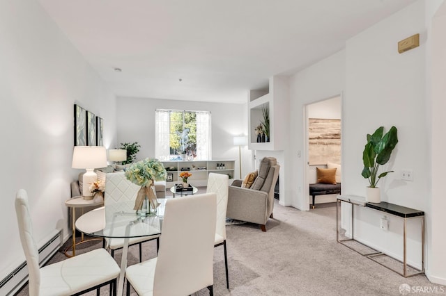 dining room with a baseboard heating unit and light colored carpet