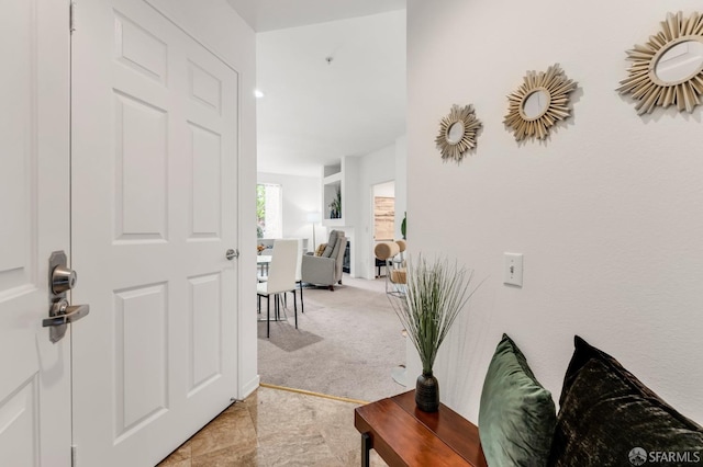 hall with light colored carpet