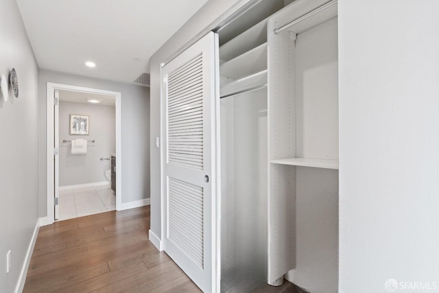 hallway with hardwood / wood-style flooring