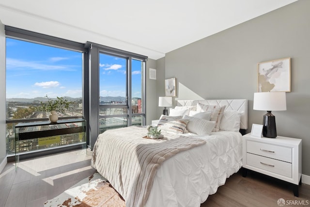 bedroom with floor to ceiling windows and dark wood-type flooring