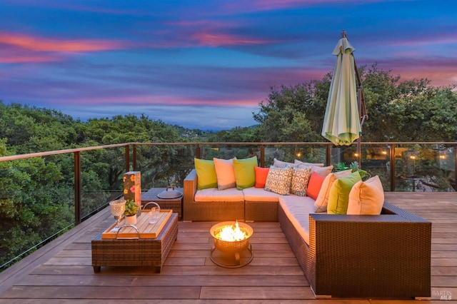 deck at dusk with an outdoor living space with a fire pit