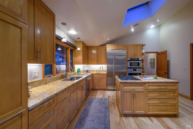 kitchen featuring a kitchen island, stainless steel appliances, a sink, and light wood-style floors