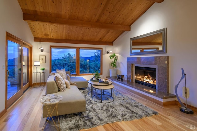 living area featuring lofted ceiling with beams, baseboards, wooden ceiling, wood finished floors, and a high end fireplace