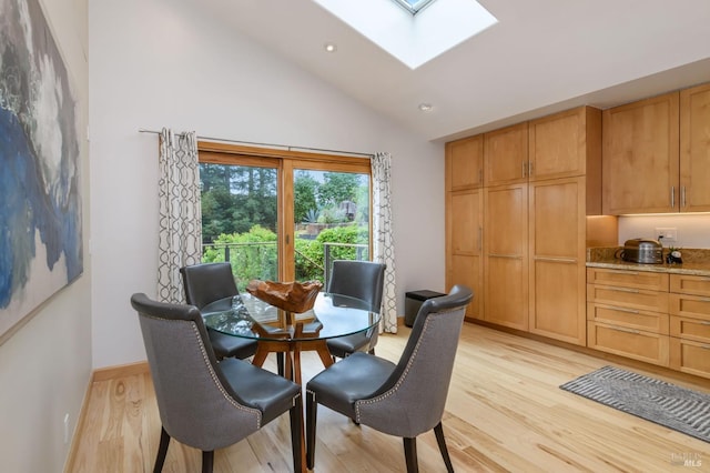 dining room featuring recessed lighting, baseboards, lofted ceiling with skylight, and light wood-style floors