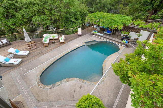 view of pool featuring a fenced in pool, fence, a wooden deck, and outdoor lounge area
