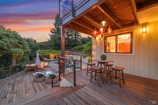deck at dusk featuring outdoor dining area