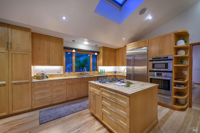 kitchen featuring wooden counters, a sink, light wood-style flooring, appliances with stainless steel finishes, and a warming drawer