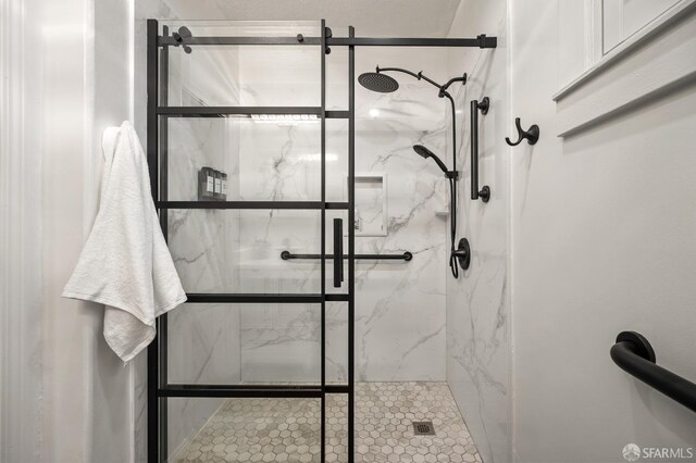 bathroom featuring a marble finish shower