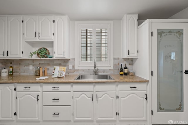 kitchen with backsplash, white cabinetry, open shelves, and a sink