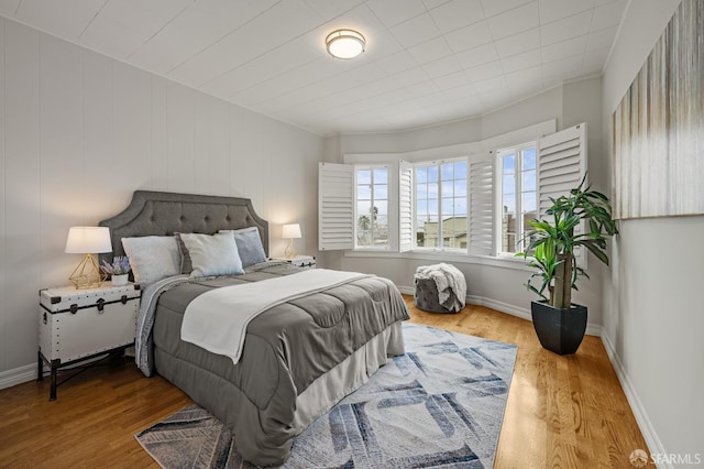 bedroom featuring wood finished floors and baseboards