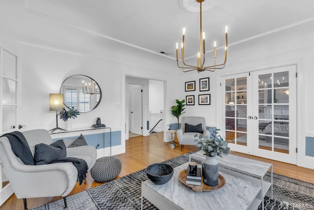 living room featuring a chandelier, hardwood / wood-style flooring, and french doors