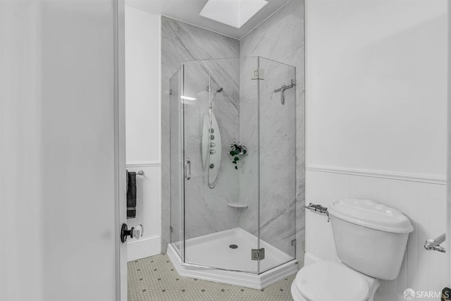 bathroom with a shower with shower door, toilet, and tile patterned floors