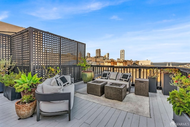 wooden deck featuring an outdoor living space with a fire pit