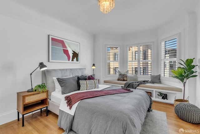 bedroom featuring a notable chandelier and hardwood / wood-style floors