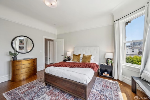 bedroom with baseboards and wood finished floors