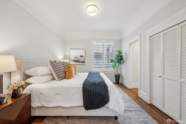 bedroom with a closet, baseboards, and wood finished floors