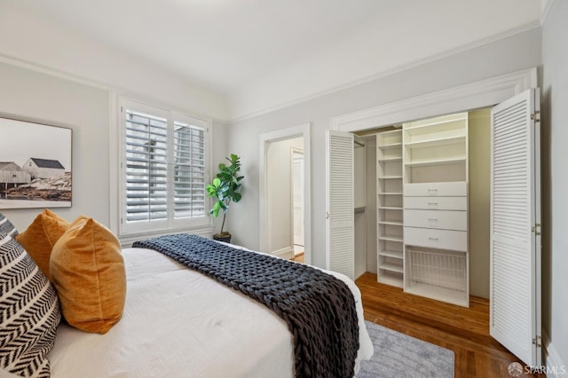 bedroom featuring crown molding and wood finished floors