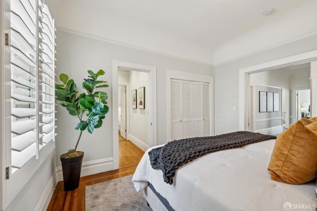 bedroom with baseboards, wood finished floors, and a closet