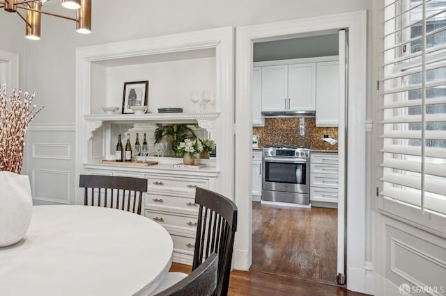 dining area featuring an inviting chandelier and dark wood-type flooring
