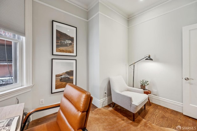 sitting room featuring baseboards, ornamental molding, and wood finished floors