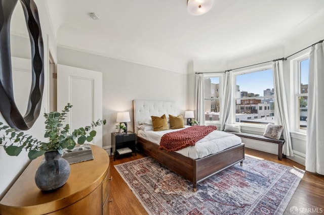 bedroom with a city view and wood finished floors