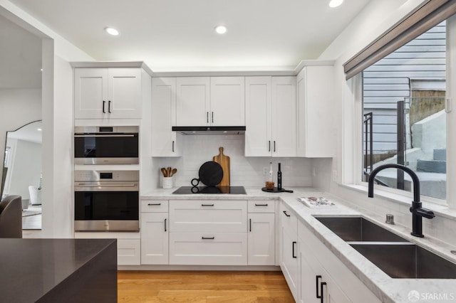 kitchen featuring white cabinetry, sink, and black electric stovetop