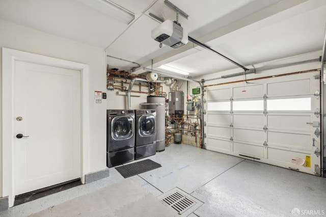 garage featuring a garage door opener, water heater, washing machine and clothes dryer, and strapped water heater