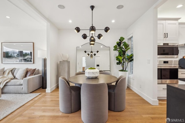 dining room with a notable chandelier and light hardwood / wood-style floors