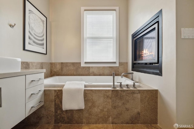 bathroom with a relaxing tiled tub and vanity