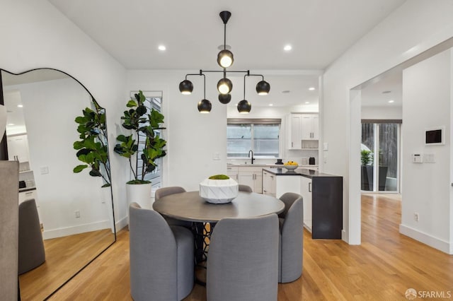 dining area with sink and light hardwood / wood-style flooring