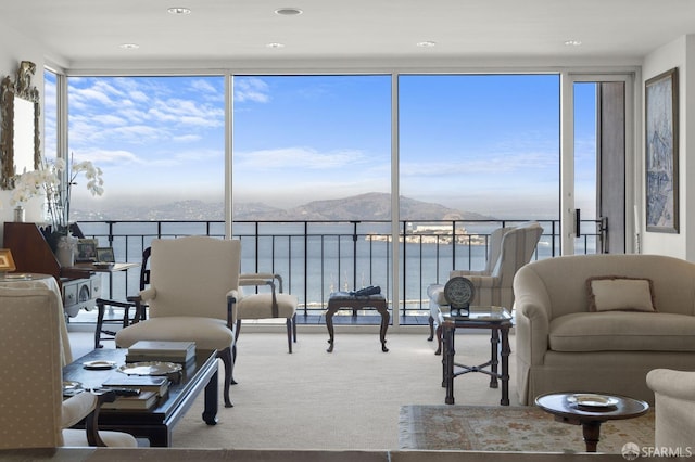 sunroom / solarium featuring a wealth of natural light and a water and mountain view