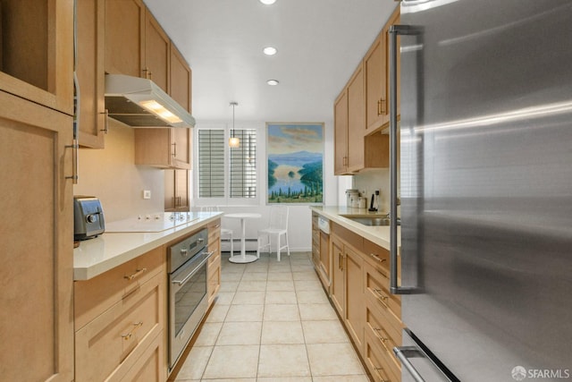 kitchen with sink, hanging light fixtures, stainless steel appliances, a baseboard heating unit, and light tile patterned floors