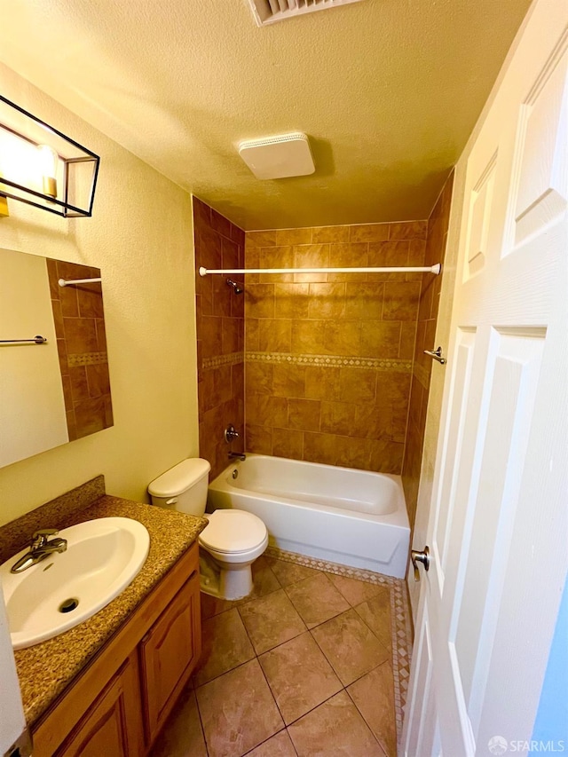 full bathroom with tiled shower / bath combo, tile patterned floors, a textured ceiling, toilet, and vanity