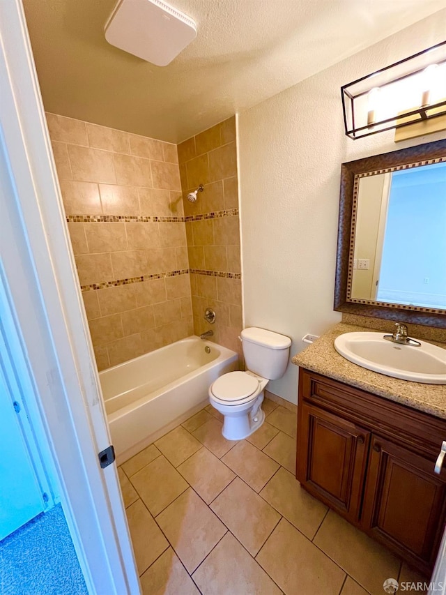 full bathroom with tile patterned floors, a textured ceiling, vanity, toilet, and tiled shower / bath