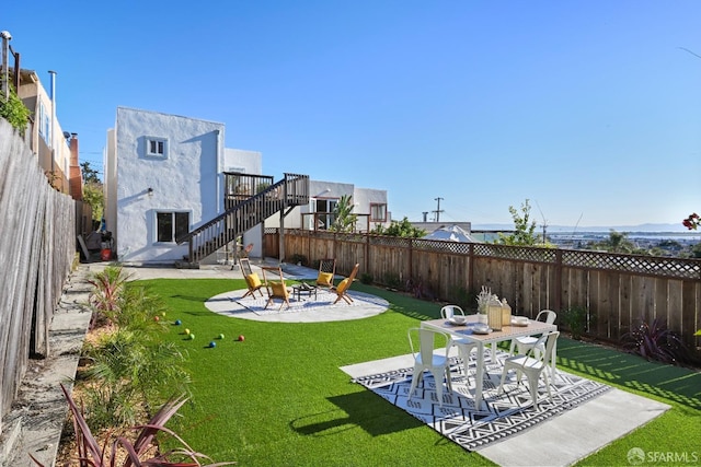 view of yard with a patio, stairway, and a fenced backyard