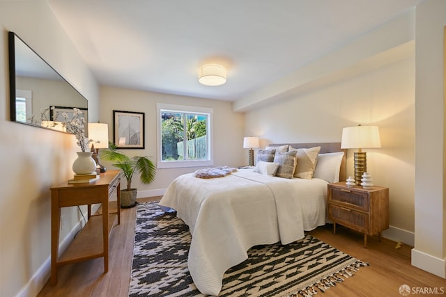 bedroom with baseboards and wood finished floors