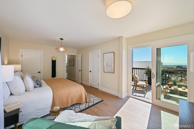 bedroom with access to exterior, baseboards, and wood finished floors