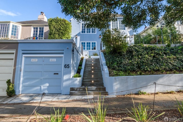 65 San Pablo Ave, San Francisco, CA 94127 - view of property featuring an attached garage, stucco siding, and stairway