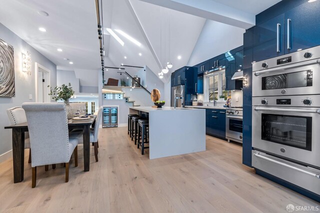 65 San Pablo Ave, San Francisco, CA 94127 - kitchen featuring light wood-style floors, blue cabinetry, appliances with stainless steel finishes, a kitchen island with sink, and light countertops