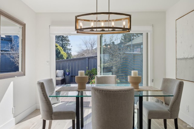 dining space with baseboards and a chandelier