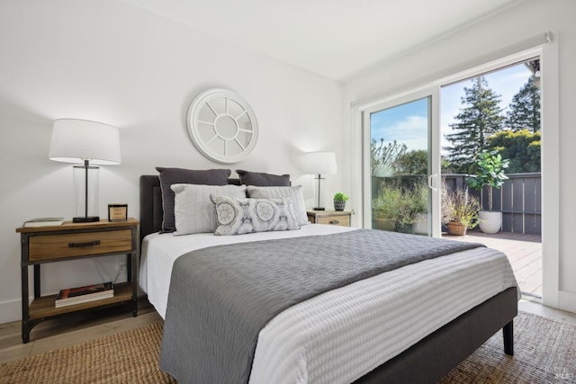 bedroom featuring access to exterior and wood finished floors