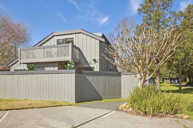 view of property exterior with a fenced front yard and a balcony