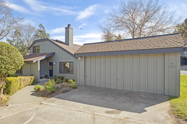 view of front of property with a shingled roof, board and batten siding, and a chimney