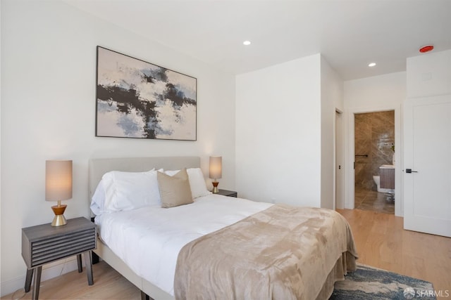 bedroom featuring light wood finished floors, recessed lighting, and connected bathroom