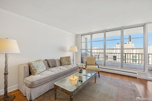 living room with a baseboard heating unit, plenty of natural light, expansive windows, and wood-type flooring