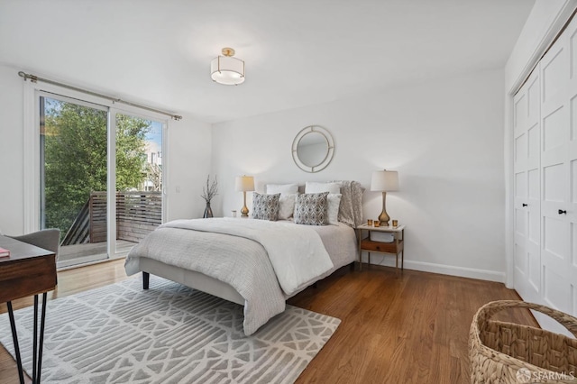 bedroom with access to exterior, a closet, and hardwood / wood-style floors